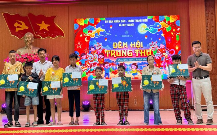 Đại diện HOIANA và lãnh đạo xã Duy Nghĩa tặng quà Trung thu cho các em. Ảnh: TUYẾT MAI