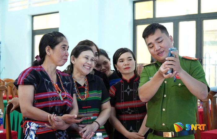 Công an xã hướng dẫn hội viên phụ nữ cách sử dụng các tiện ích trên VNeID. Ảnh: PƠ LOONG PHÁI