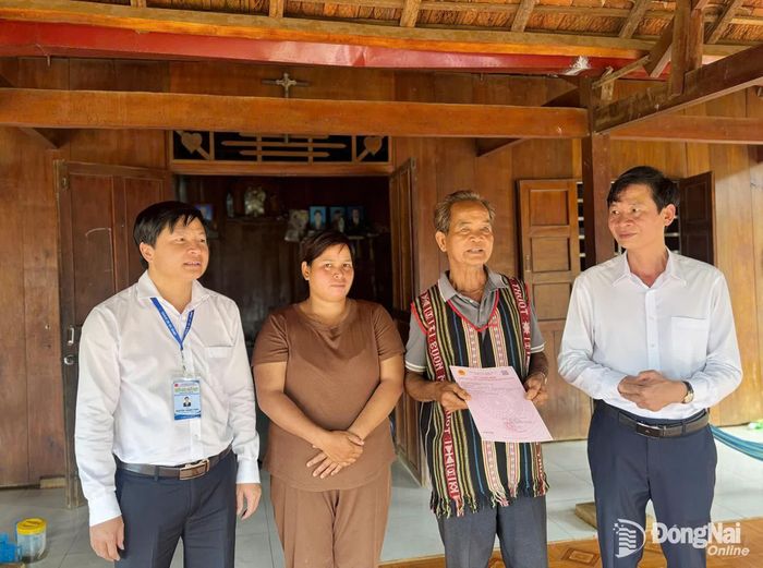 Đại diện lãnh đạo xã Bù Đăng trao sổ đỏ tại nhà cho người dân. Ảnh: CTV