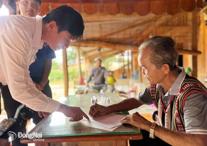 Người dân xã Bù Đăng ký nhận sổ đỏ tại nhà. Ảnh: CTV