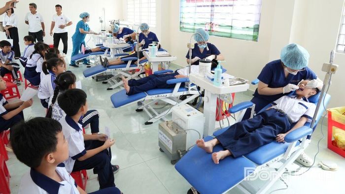 Học sinh được bác sĩ khám răng sau Lễ triển khai chương trình.