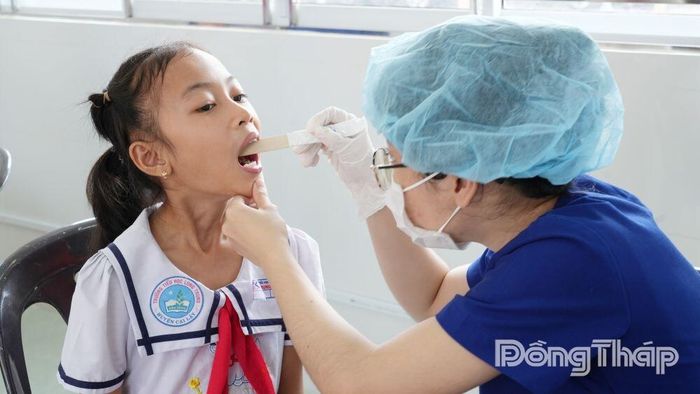 Học sinh được bôi vecni fluor dự phòng sâu răng.