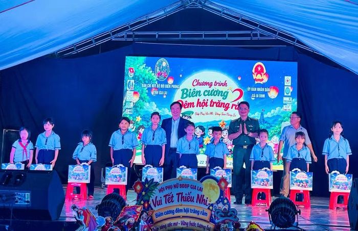 Phó Chủ tịch Thường trực UBND tỉnh và Chính ủy BĐBP tỉnh tặng quà cho thiếu nhi. Ảnh: P.D