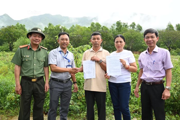 Hộ dân nhận biên bản giao đất tái định cư trên thực địa.
