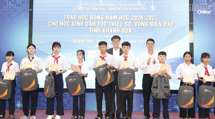 Lãnh đạo Sở Giáo dục và Đào tạo và đại diện nhà tài trợ trao học bổng cho học sinh.