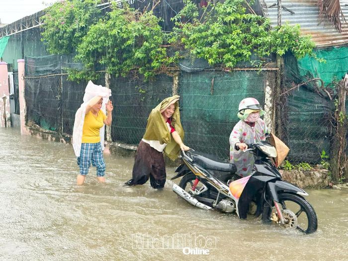 Nhiều xe máy bị chết máy khi đi qua đoạn ngập trên đường Trường Chinh, người dân phải dắt bộ.