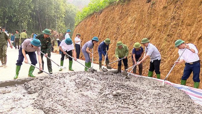  Các đại biểu và Nhân dân tham gia đổ bê tông đường tại thôn Ngòi Sọng. 