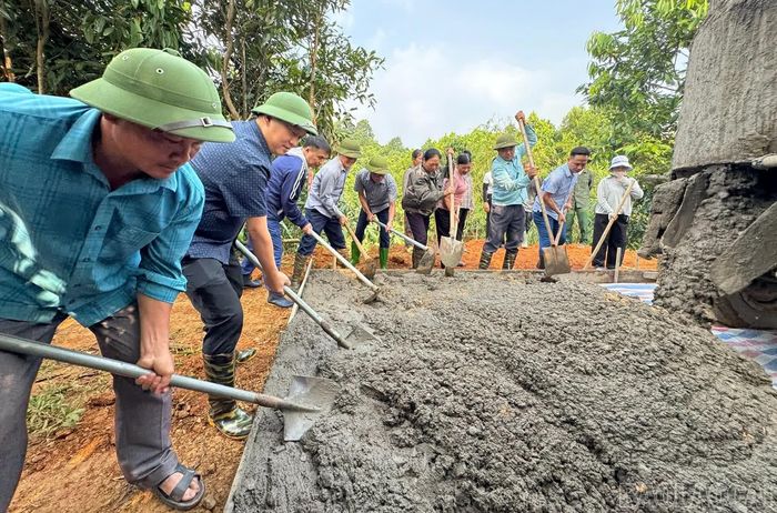  Các đại biểu và người dân tham gia đổ bê tông tuyến đường thôn Sông Hồng. 