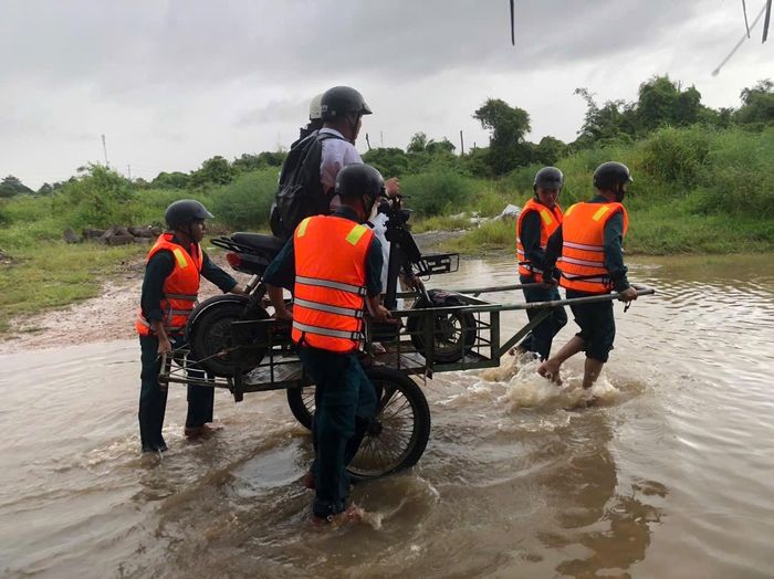 Học sinh được các lực lượng xã Hàm Kiệm hỗ trợ qua vùng ngập