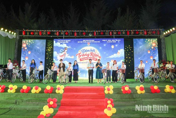 Các đồng chí lãnh đạo trao xe đạp cho các em thiếu nhi có hoàn cảnh khó khăn vươn lên trong học tập. Ảnh: Minh Quang