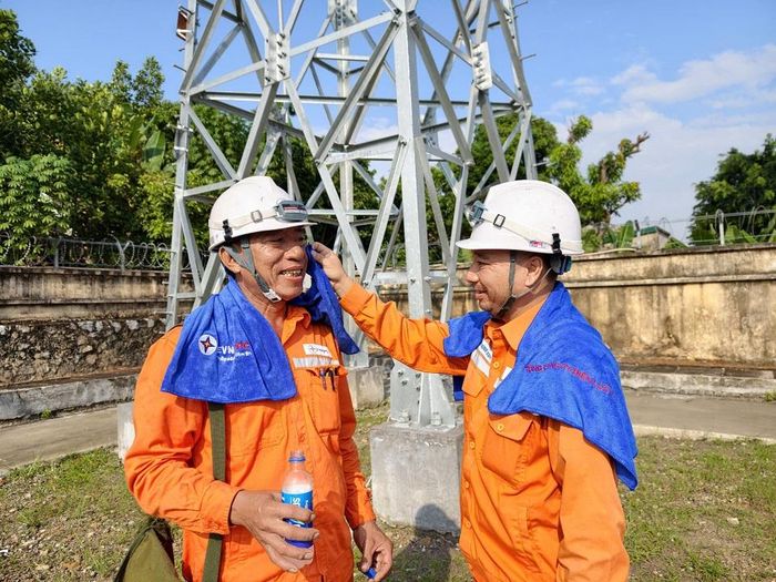 Nhân viên Công ty Điện lực Quảng Ninh hỏi thăm, động viên đồng nghiệp vừa hoàn thành phiên công tác trên cao