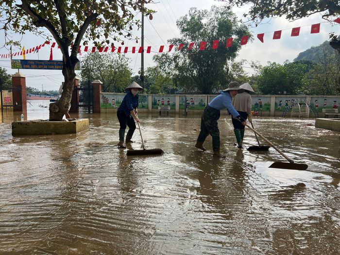 Nước trong sân trường đã rút hết, nhưng khu vực ngoài cổng vẫn còn ngập nên học sinh chưa thể trở lại lớp.