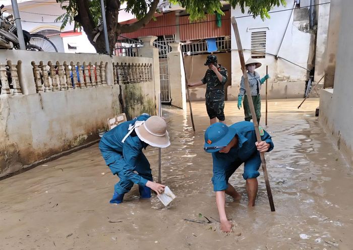 Lực lượng chức năng phối hợp thu gom rác thải, xử lý bùn đất và hỗ trợ các hộ dân bị ảnh hưởng.