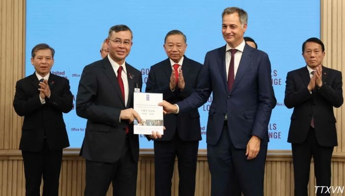 Bộ trưởng Bộ Tài chính Ngô Văn Tuấn và Tổng Giám đốc điều hành UNDP Alexander De Croo trao văn kiện. Ảnh: TTXVN