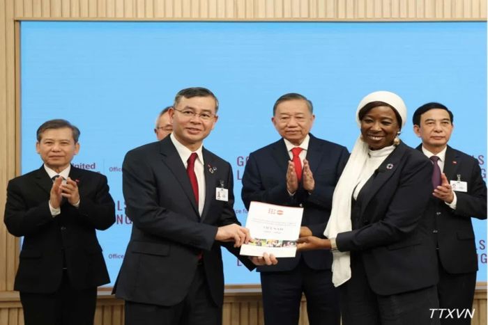 Bộ trưởng Ngô Văn Tuấn và Giám đốc điều hành UNFPA Diene Keita trao văn kiện. Ảnh: TTXVN