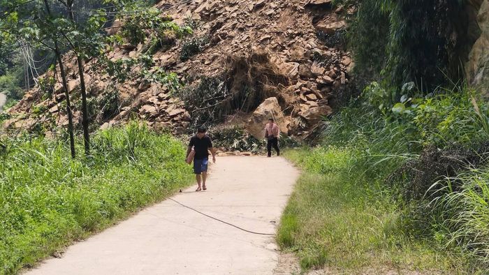 Người dân vẫn có thể đi bộ để qua khu vực sạt lở để mua hàng hoá, thực phẩm.