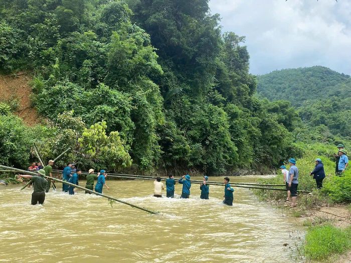 Công an xã Yên Na cùng người dân làm cầu tạm qua suối sau sạt lở, bảo đảm việc đi lại và đưa học sinh trở lại trường. Ảnh: Công an Nghệ An
