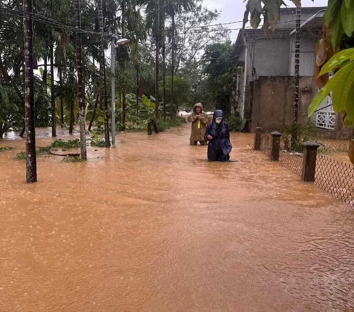 Công an xã Hưng Lộc giúp người dân di chuyển qua vùng ngập lụt.