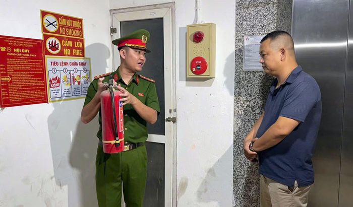 Đại úy Nguyễn Tiến Đức, cán bộ Đội CC&CNCH khu vực số 12 hướng dẫn người dân tại các khu nhà trọ, nhà ở kết hợp cho thuê kiểm tra tình trạng hoạt động bình chữa cháy.