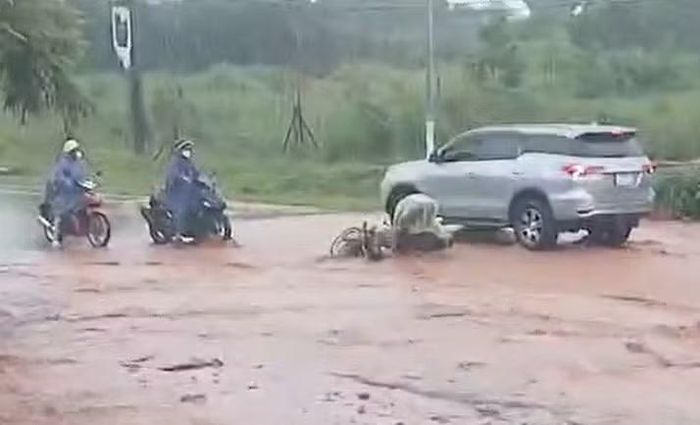 Cát đỏ tràn xuống đường khiến người đi đường bị ngã.