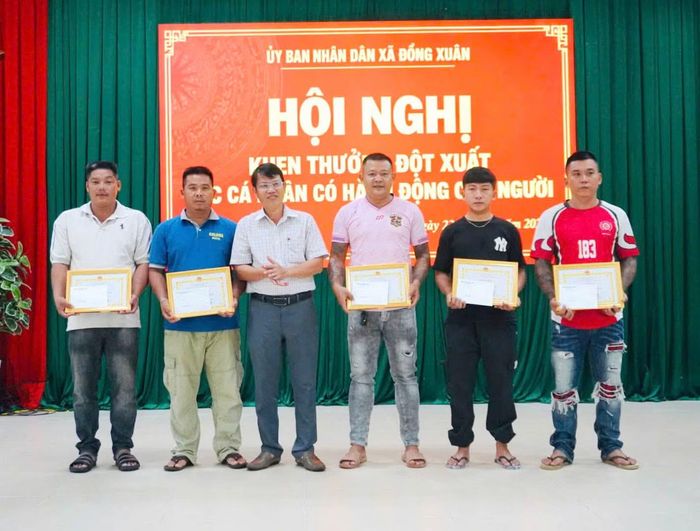 Ông Nguyễn Ngọc Tuấn, Chủ tịch UBND xã Đồng Xuân (thứ ba, từ trái sang) trao giấy khen cho 5 cá nhân đã có hành động dũng cảm cứu nạn nam thiếu niên.