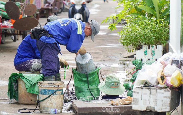 Công nhân khẩn trương nạo vét, thu gom rác tại hệ thống hố ga trong Hẻm 78, đường Trần Hưng Đạo, phường Tân Thành, để khơi thông dòng chảy, hạn chế ngập úng.
