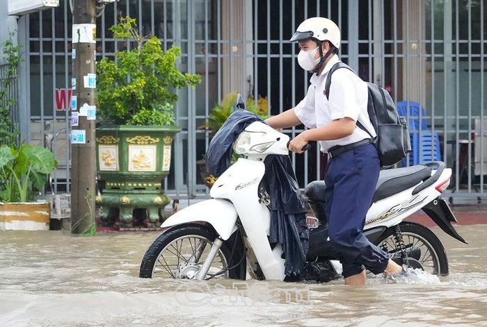 Học sinh không dám chạy, phải dẫn xe qua đoạn đường ngập sâu, để tránh nguy hiểm. 