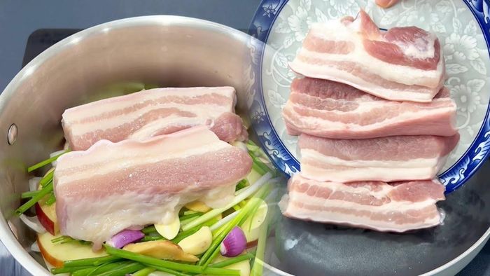 Xếp gừng, sả và hành lá xuống đáy nồi thành một lớp mỏng. Lớp nguyên liệu này vừa tạo hương thơm vừa giúp miếng thịt không tiếp xúc trực tiếp với đáy nồi trong thời gian dài. Ảnh minh họa.
