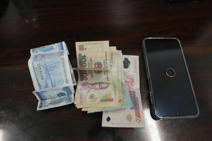 Số tiền, điện thoại và nhẫn vàng là tang vật của vụ án. (Ảnh: Công an Quảng Trị)