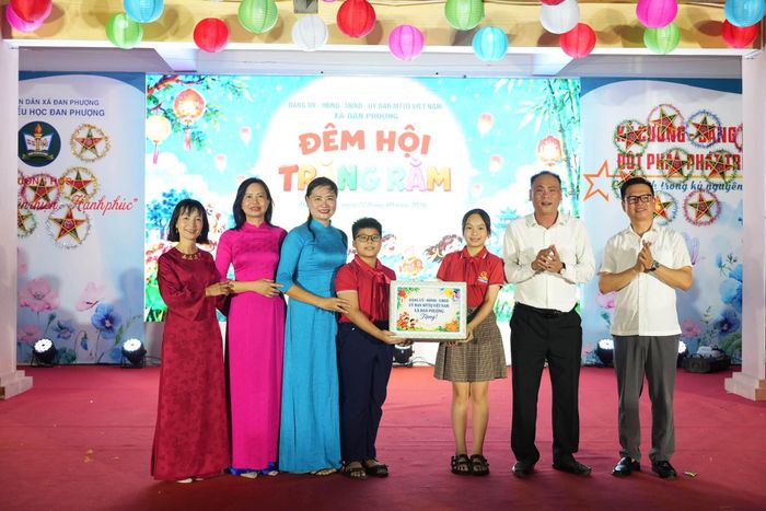Bí thư Đảng ủy, Chủ tịch HĐND xã Đan Phượng Nguyễn Gia Hiển và Phó Chi cục trưởng Chi cục Dân số, Trẻ em và Phòng, chống tệ nạn xã hội Hà Nội Nguyễn Văn Lập trao quà cho các em nhỏ. Ảnh: Nguyễn Ngân