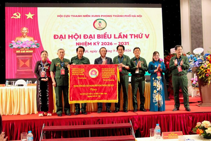 Chủ tịch Hội Cựu TNXP Việt Nam Thân Đức Nam tặng cờ truyền thống của Trung ương Hội tại Đại hội. Ảnh: Ánh.