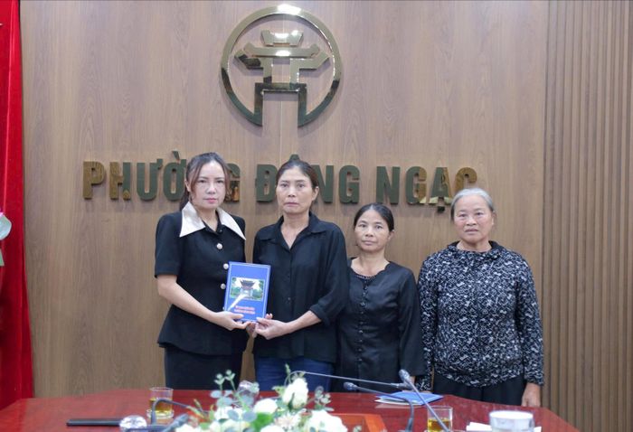 Phó Chủ tịch UBND phường Đông Ngạc Nguyễn Thị Hương trao kinh phí hỗ trợ của phường đến gia đình nạn nhân. Ảnh: Linh Khánh