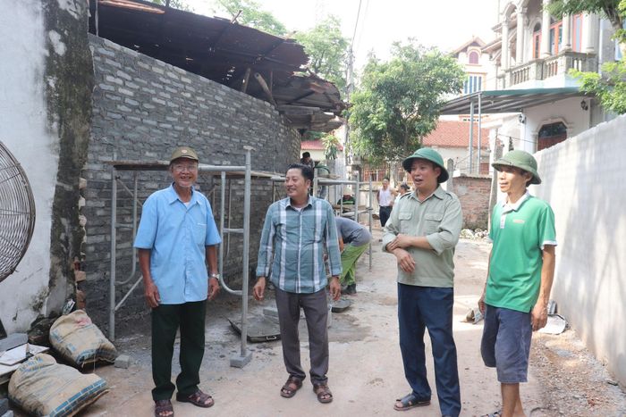 Các đồng chí cán bộ thôn Đống (cũ), nay là thôn Cao Bộ trao đổi với người dân tại tuyến đường Ngang, xóm Chợ thời điểm chỉnh trang, mở rộng đường. Ảnh T. Đạt