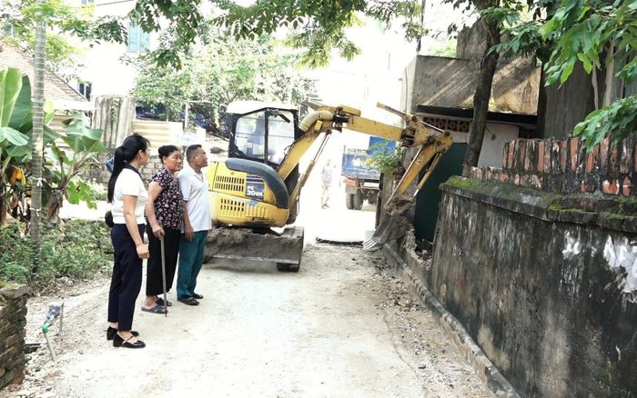 Người góp của, người góp công, người hỗ trợ máy móc thi công để mở rộng tuyến đường ngõ tại thôn Cao Viên. Ảnh T. Đạt
