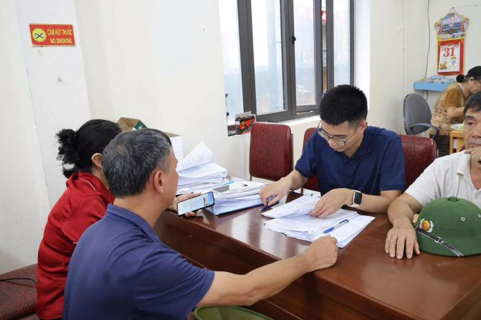 Người dân ký xác nhận hồ sơ xác nhận nguồn gốc đất. Ảnh: PV