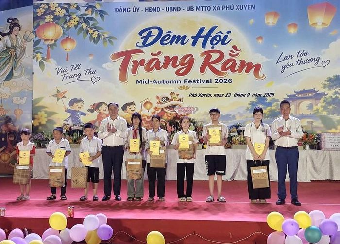 Lãnh đạo xã Phú Xuyên trao tặng quà cho các em có hoàn cảnh khó khăn. Ảnh: PV