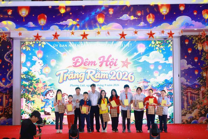 Phó Chủ tịch Uỷ ban MTTQ Việt Nam thành phố Hà Nội Phạm Anh Tuấn và Bí thư Đảng uỷ, Chủ tịch HĐND phường Phương Liệt Nguyễn Minh Tiến trao học bổng cho học sinh có hoàn cảnh đặc biệt. Ảnh: NT