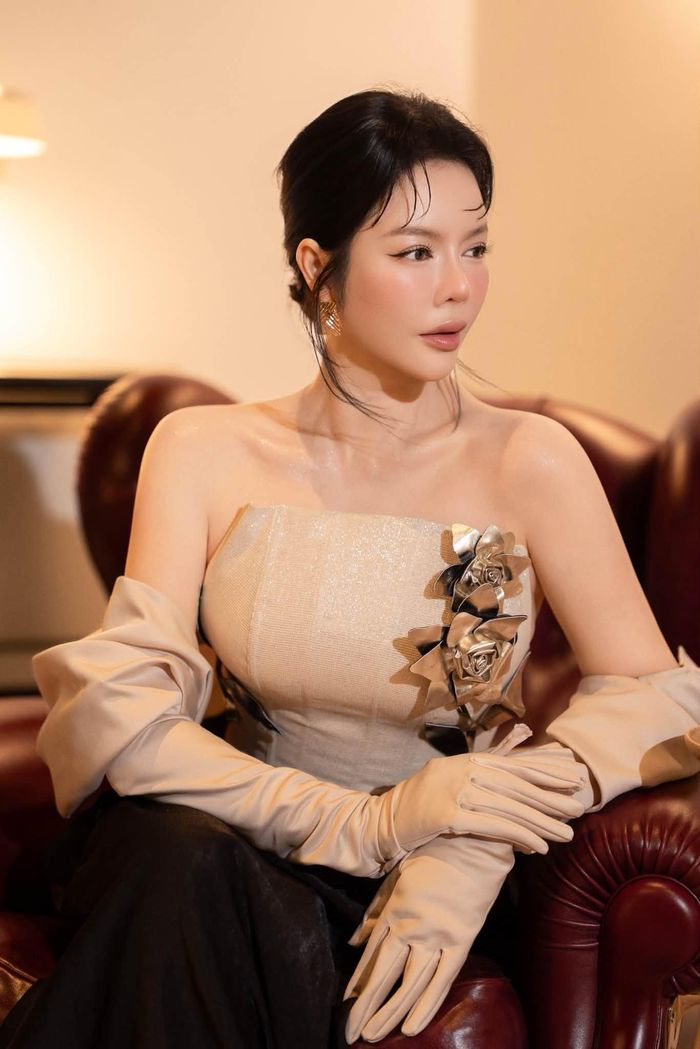 Lý Nhã Kỳ thu hút chú ý khi diện trang phục phong cách cổ điển với váy cúp ngực đính họa tiết 3D dáng dài, phối găng tay opera màu beige cách điệu như một chiếc áo choàng nhẹ.