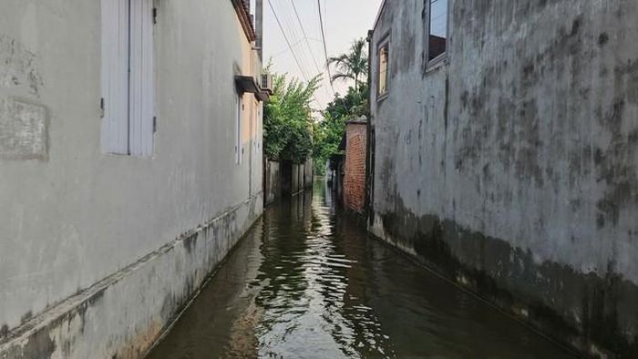 Tuy nhiên, tại một số con ngõ hẹp và sâu trong làng, nước rút chậm nên đến chiều 22/9 vẫn còn ngập quá đầu gối.