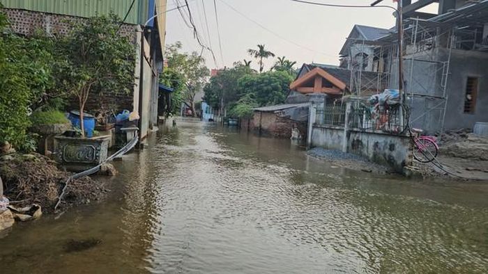 Tuyến đường chính qua làng, nước đã cạn bớt, giúp việc đi lại của người dân bớt khó khăn hơn so với thời điểm đỉnh lũ.