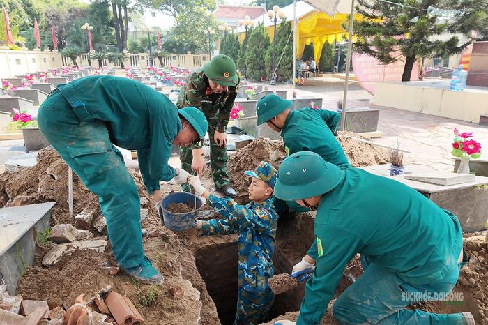 Dân quân tự vệ phối hợp vận chuyển đất từ phần mộ. Ảnh: Tuấn Anh
