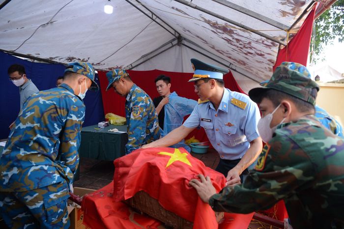 Tiểu đựng hài cốt liệt sĩ được phủ Quốc kỳ trước khi di chuyển. Ảnh: Tuấn Anh
