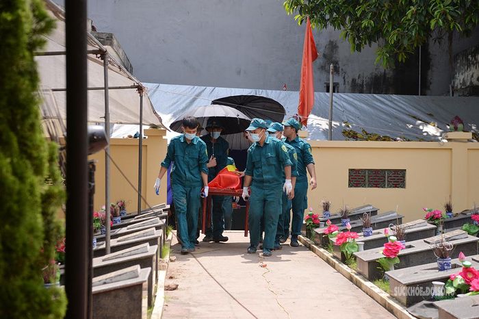 Lực lượng dân quân tự vệ di chuyển phần hài cốt liệt sĩ. Ảnh: Tuấn Anh