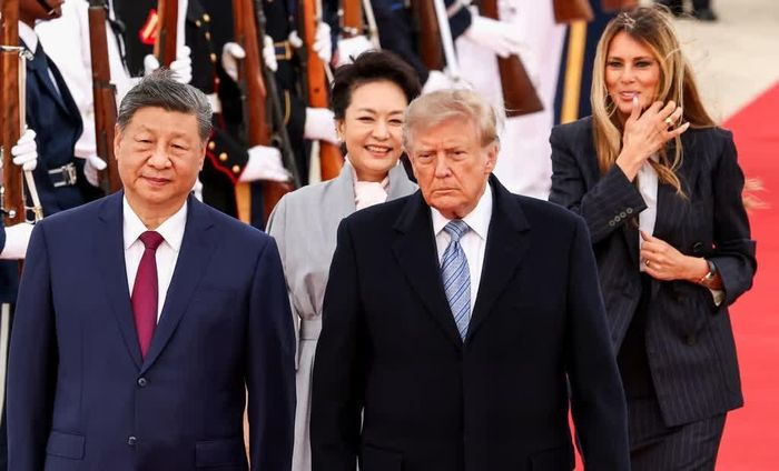 Trang phục của hai cặp lãnh đạo Mỹ - Trung trong lễ đón cũng thu hút sự chú ý. Bà Melania Trump diện bộ suit màu tối, kết hợp với sơ mi trắng, trong khi bà Bành Lệ Viên mặc đầm xanh xám nhạt và quàng khăn nhẹ. Ông Tập Cận Bình chọn vest tối màu cùng cà vạt đỏ đun. Tổng thống Donald Trump cũng mặc vest tối màu, phối cà vạt kẻ xanh xám và mặc áo măng tô, đeo găng tay.