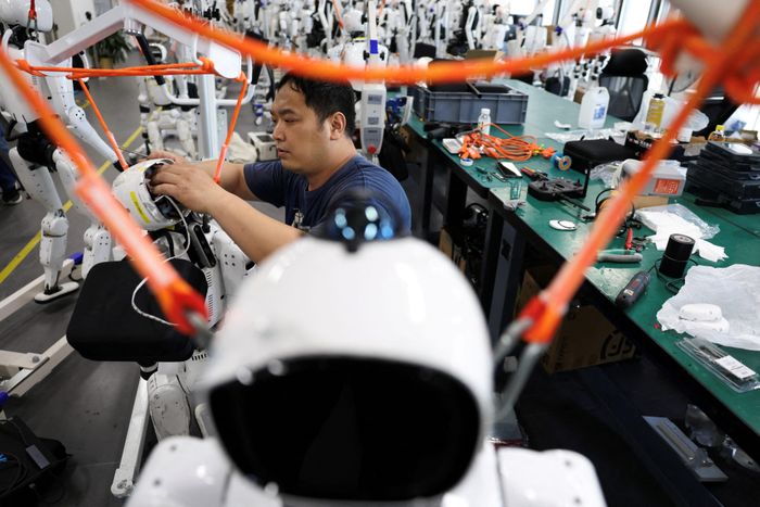 Một kỹ sư đang làm việc trên robot hình người Tiangong Omni tại khu vực nghiên cứu và thử nghiệm của Trung tâm Đổi mới Robot Hình người Bắc Kinh (Trung Quốc). Ảnh: Reuters.