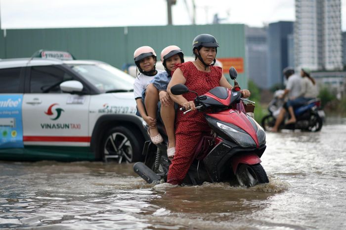 Chiều muộn, nhân viên văn phòng, trẻ em tan học, lượng phương tiện đổ về đường Lương Định Của ngày càng đông. Tình trạng ngập kéo dài tiềm ẩn nguy hiểm cho người dân.