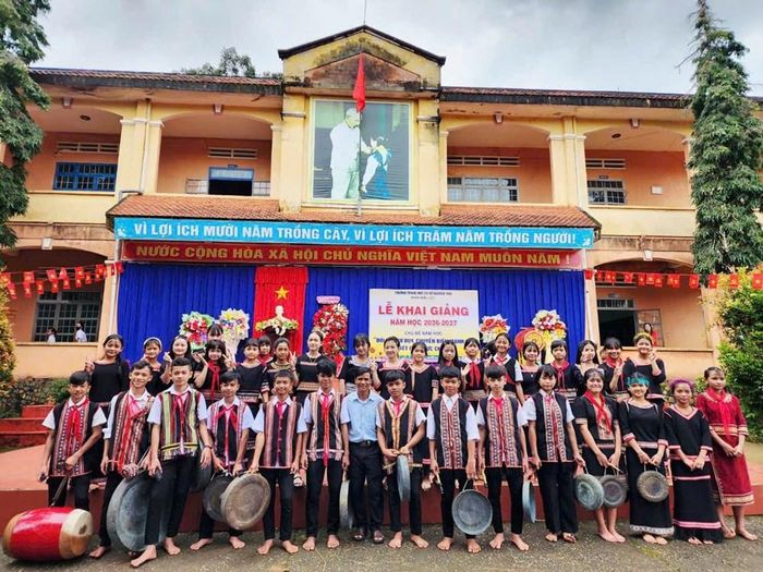 Nghệ nhân A Thu cùng các em học sinh trong đội cồng chiêng, múa xoang Trường THCS Nguyễn Trãi chụp ảnh lưu niệm sau khi biểu diễn tại Lễ khai giảng năm học mới