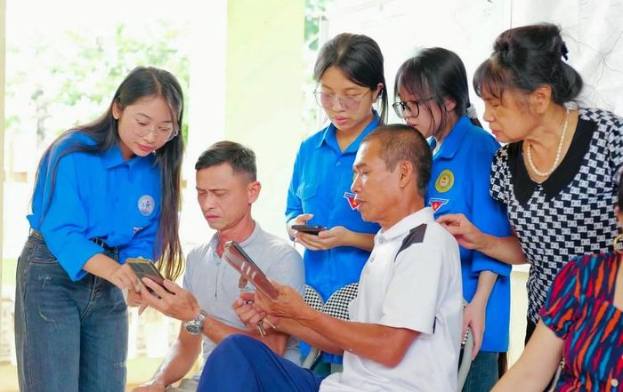 Đoàn viên thanh niên tỉnh Bắc Ninh hướng dẫn người dân sử dụng các tiện ích số trên điện thoại. Ảnh: Đồng Thúy - TTXVN