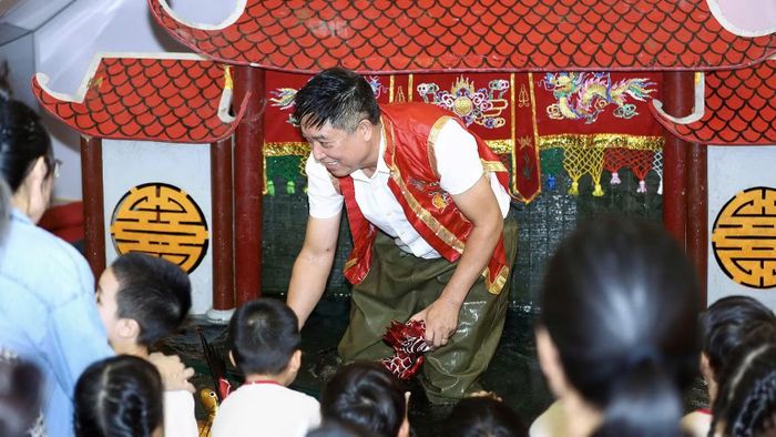 Nghệ sĩ Phan Thanh Liêm giới thiệu với các khán giả nhỏ tuổi về nghệ thuật rối nước.