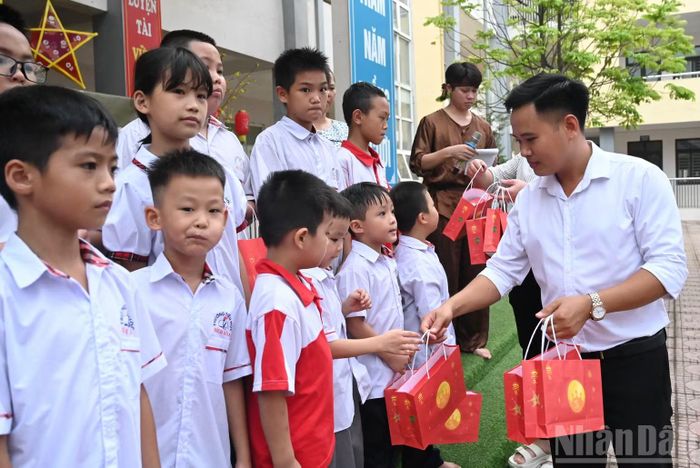 Ông Nguyễn Đức Đỉnh, Trưởng đại diện phân hiệu Bích Hòa trường Tiểu học Hùng Vương trao quà cho các con học sinh có hoàn cảnh đặc biệt, khó khăn.